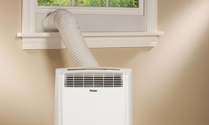 Portable air conditioner with exhaust hose connected to a window